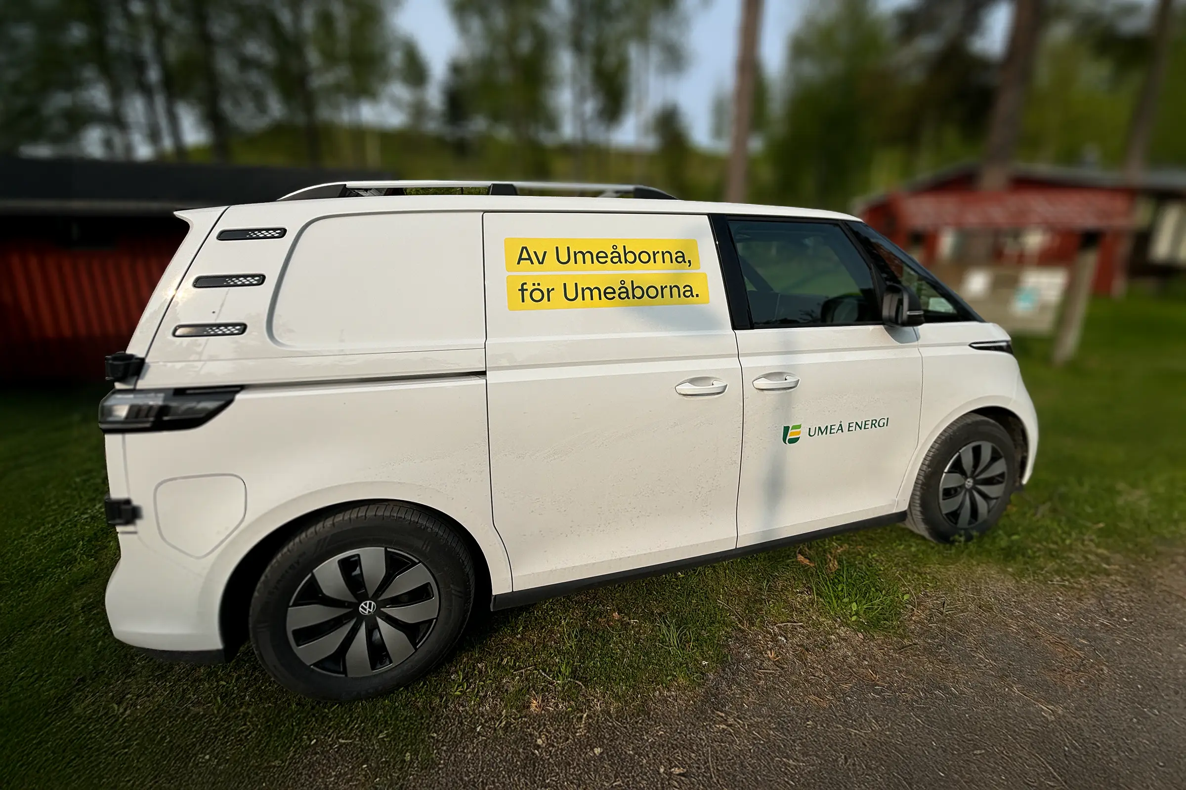 Vit servicebil profilerad med Umeå Energis logotyp och budskapet Av Umeåborna, för Umeåborna