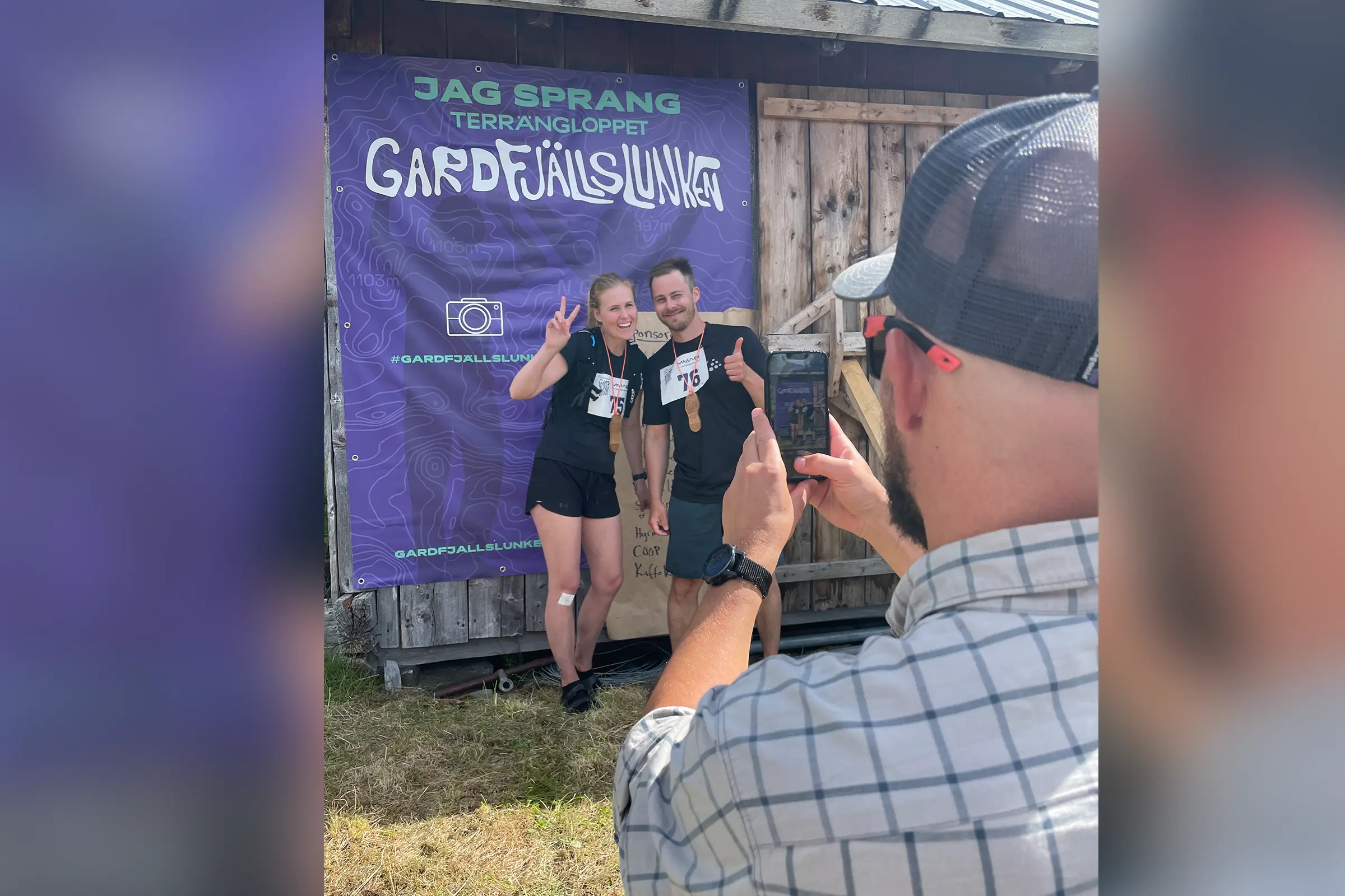 Deltagare fotograferas framför Gardfjällslunkens fotovägg efter loppet